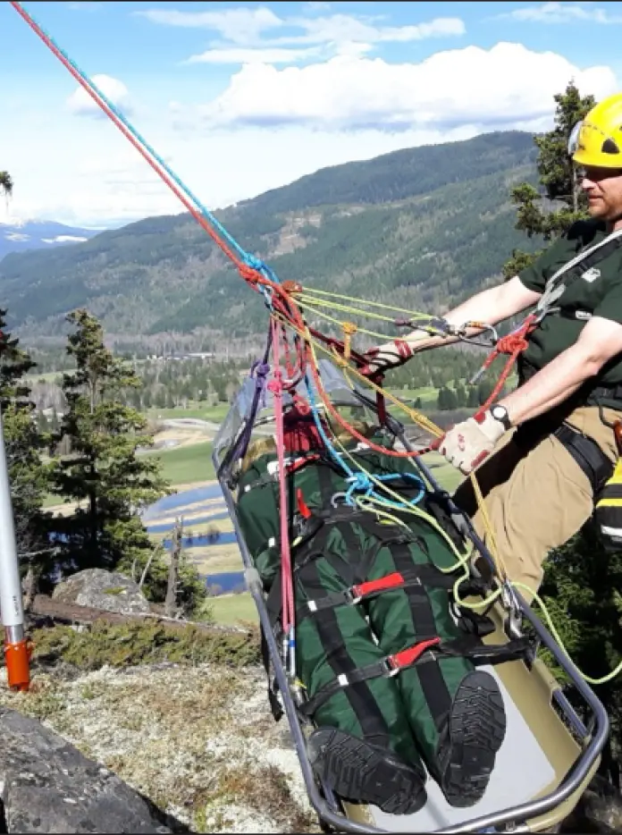 Man on practising helping someone down a mountain